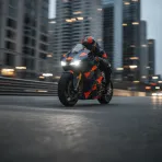 A MotoGP bike races through a city street circuit at dusk, with tall buildings visible in the background.