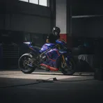 Fabio Quartararo stands looking pensive inside the Monster Energy Yamaha team garage.