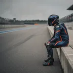 Italian rider Francesco Bagnaia sits in his team garage, looking pensive as he analyses data between sessions.