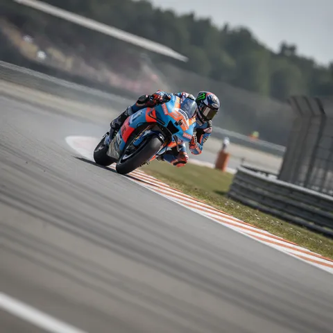 A MotoGP rider carefully guides their motorcycle down the steep and notorious Waterfall corner at the Sachsenring circuit.