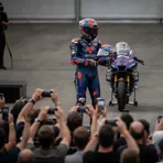 A MotoGP rider presents a signed helmet for auction at the GP of Champions charity event at Silverstone.