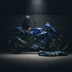 A factory Yamaha MotoGP bike sits under a spotlight in a garage, representing the team's future project.
