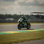 Spanish rider Jorge Martin celebrates securing pole position for the Dutch Grand Prix next to his Aprilia motorcycle.