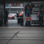 An empty garage space in the MotoGP pits, representing a rider's absence due to injury.