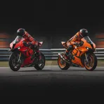 A split image showing a red Ducati and an orange KTM racing motorcycle, representing the two different factory teams the Marquez brothers will ride for.