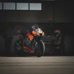 Maverick Viñales sits alone on a pit wall, looking thoughtful after a practice session.