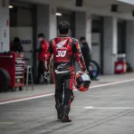A Japanese rider in Honda leathers walks through the pit lane at the Motegi circuit ahead of his wildcard appearance.