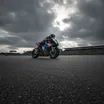 A MotoGP bike leans hard through the famous esses at the Silverstone circuit.
